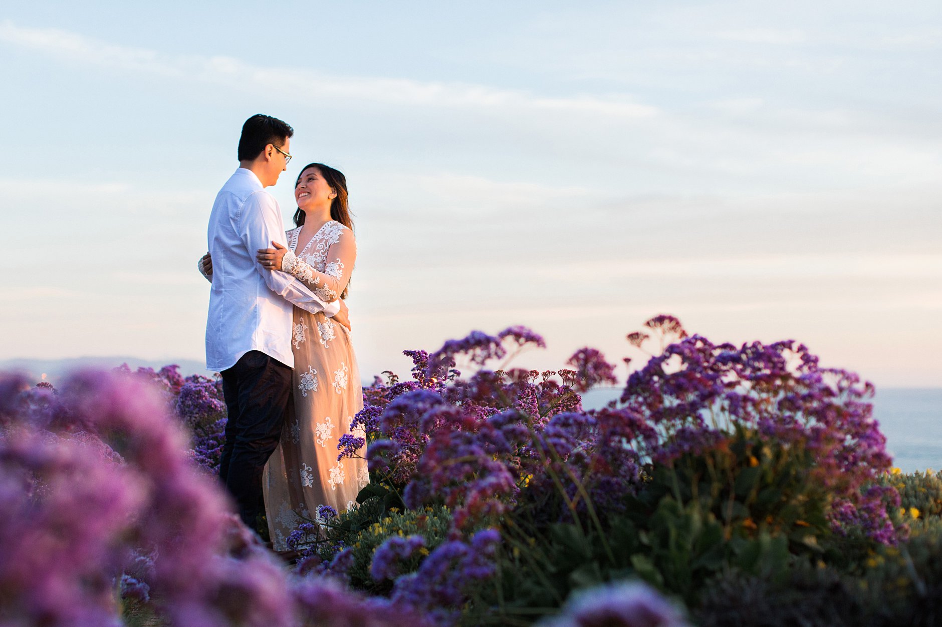 Purple flowers and dancing couple. Romantic sunset session at the cliff of Del Mar.